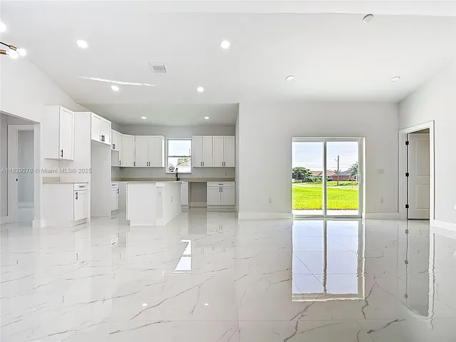 a kitchen with stainless steel appliances a table and chairs in it