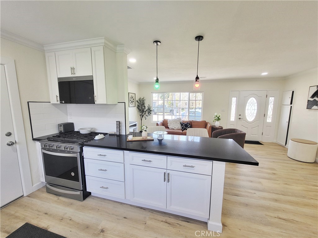 13927 Brightwell Avenue Paramount, CA 90723 - Photo 13 of 36 a kitchen with granite countertop a sink a stove and cabinets