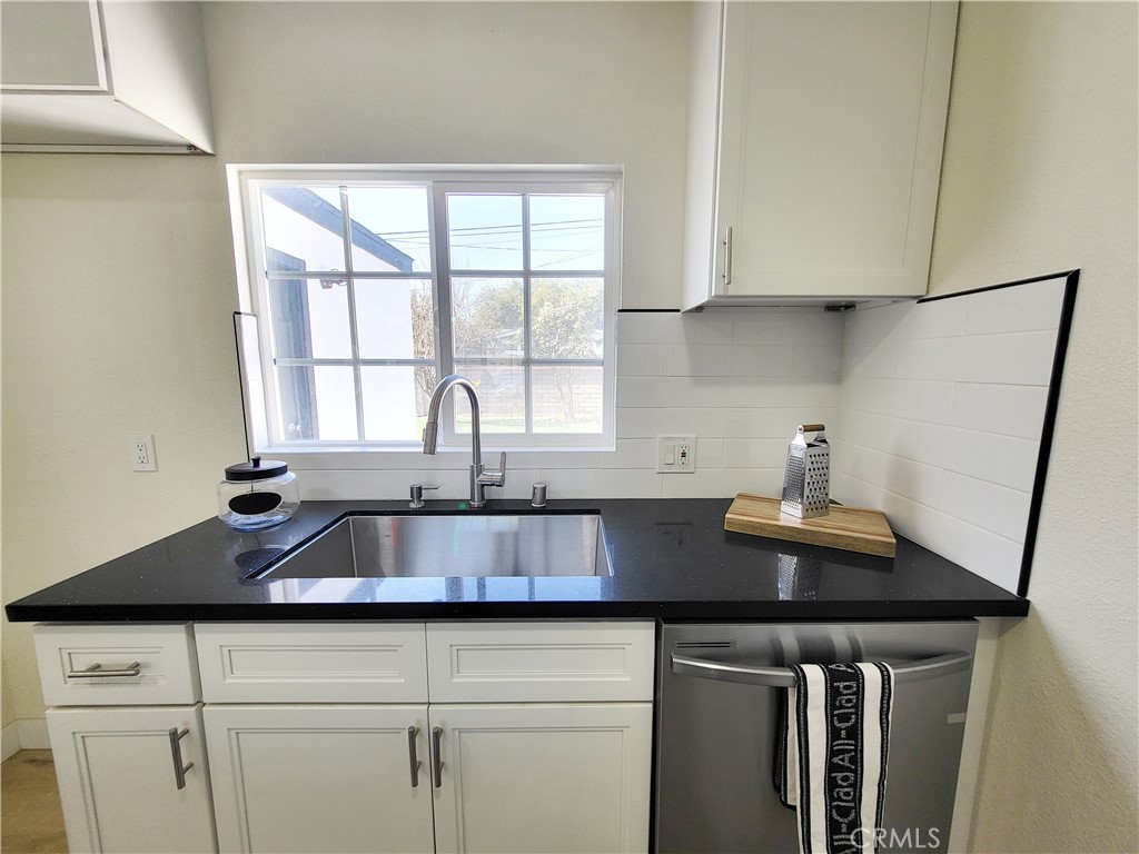 13927 Brightwell Avenue Paramount, CA 90723 - Photo 15 of 36 a kitchen with stainless steel appliances a sink a stove and white cabinets