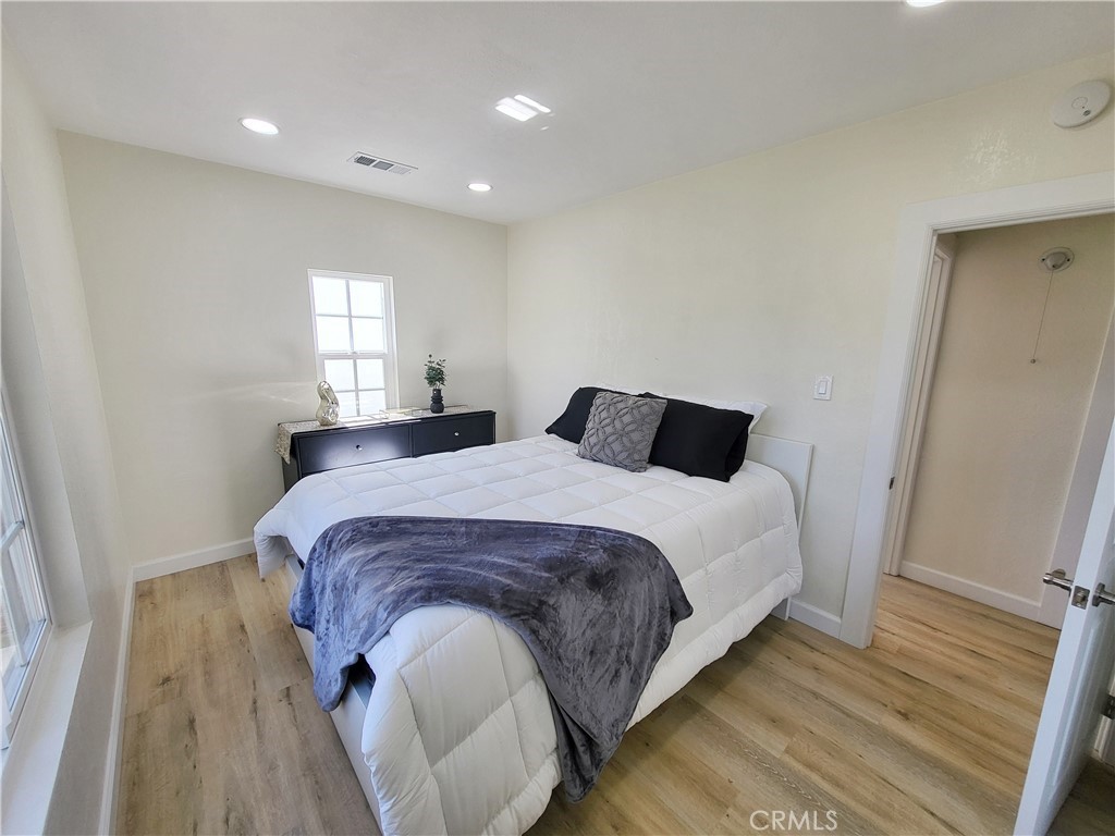 13927 Brightwell Avenue Paramount, CA 90723 - Photo 23 of 36 a bedroom with a bed and wooden floor