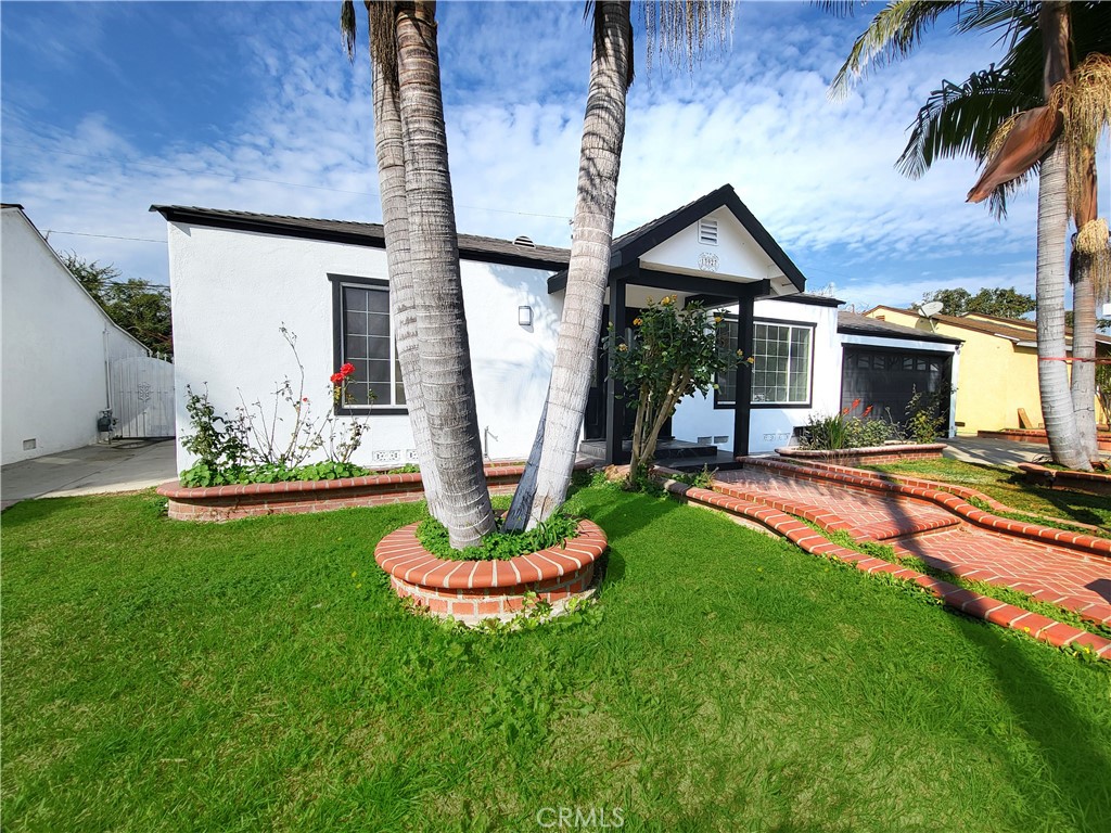 13927 Brightwell Avenue Paramount, CA 90723 - Photo 3 of 36 a front view of a house with a yard table and chairs