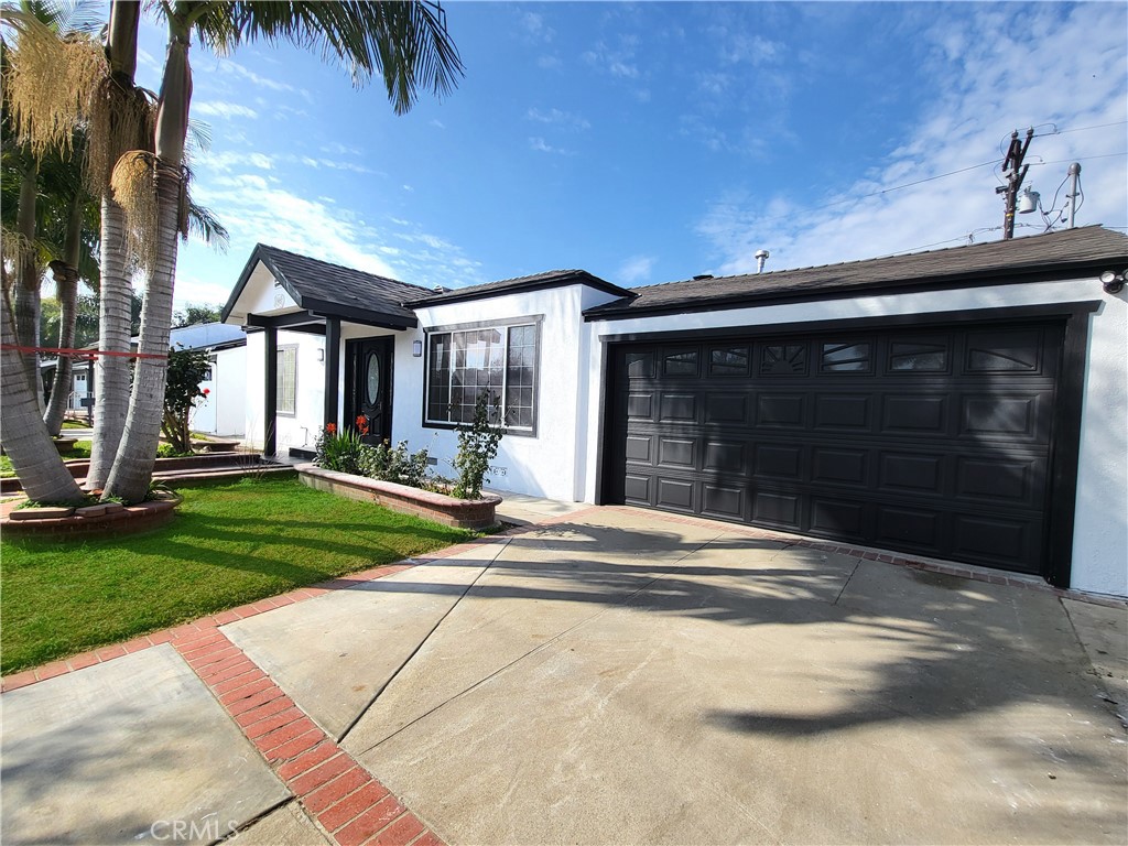 13927 Brightwell Avenue Paramount, CA 90723 - Photo 5 of 36 a front view of a house with a yard and garage