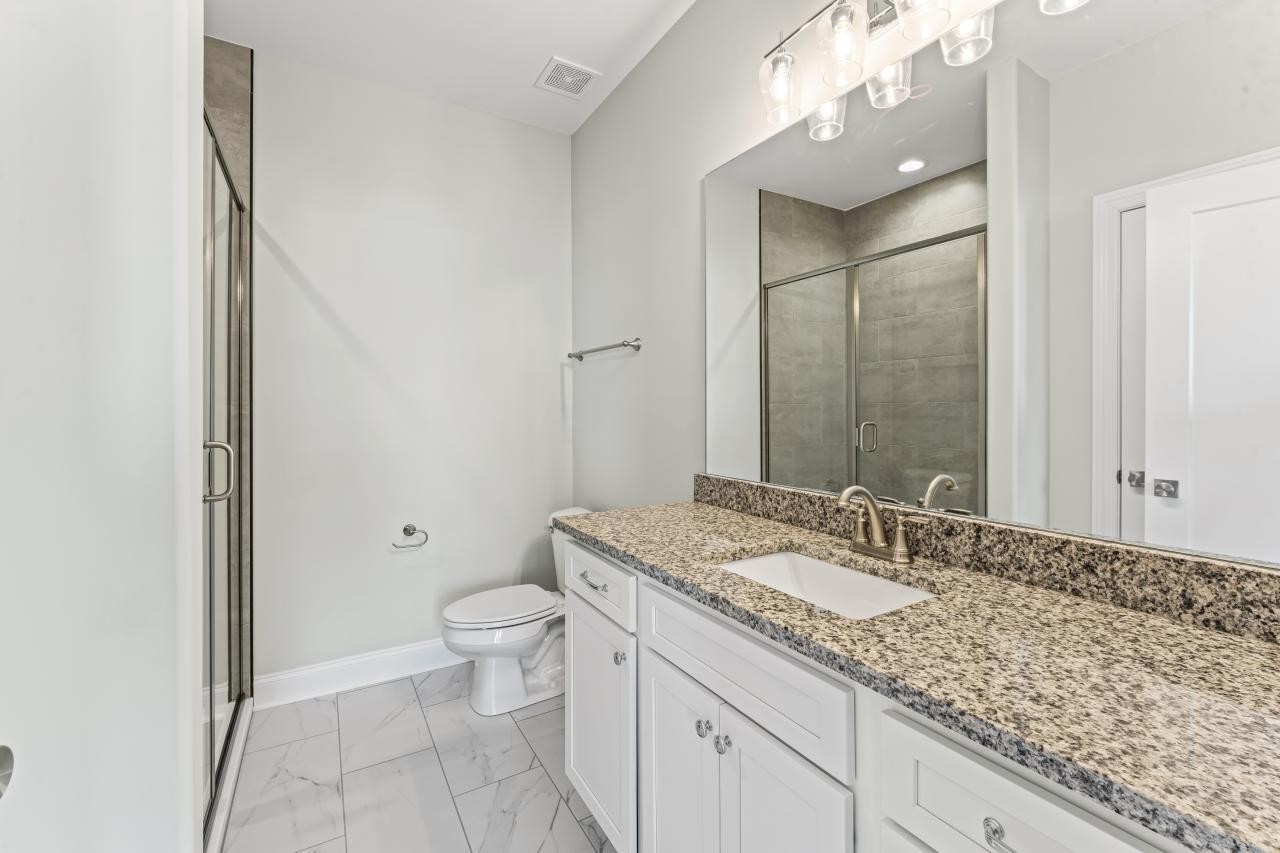 2132 Gracie Bug Loop Murfreesboro, TN 37128 - Photo 4 of 24 a bathroom with a granite countertop sink a toilet and a mirror