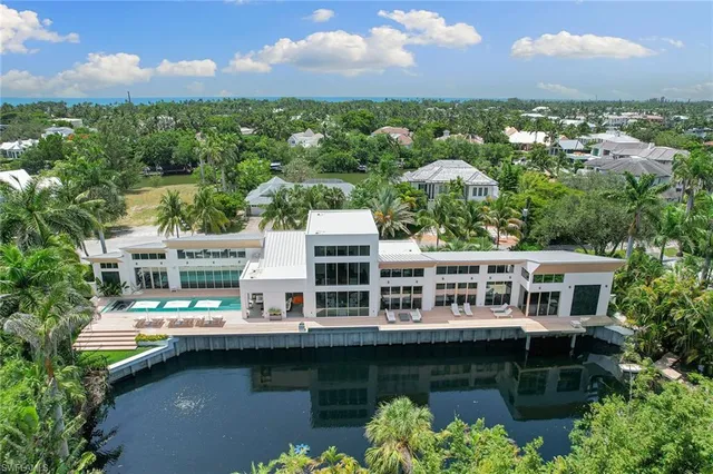 an aerial view of lake residential houses with outdoor space and swimming pool