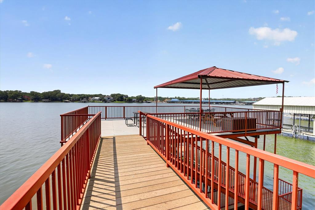 8877 Random Road Fort Worth, TX 76179 - Photo 30 of 40 Waterfront deck featuring a covered seating area, composite decking, and red metal railings