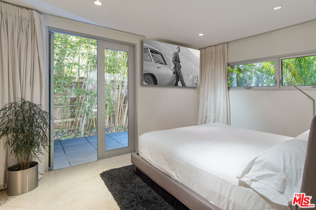 1466 Bel Air Road Los Angeles, CA 90077 - Photo 26 of 35 a bedroom with a large bed and a potted plant