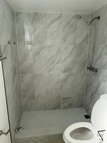 a bathroom with a toilet and a shower