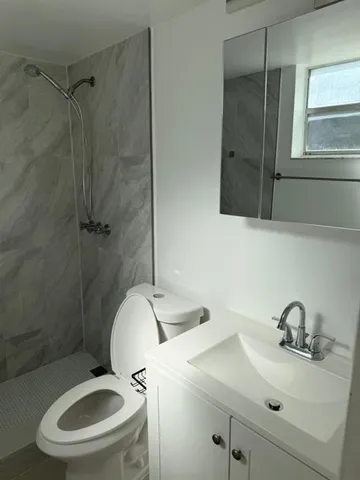 a bathroom with a sink mirror toilet and shower