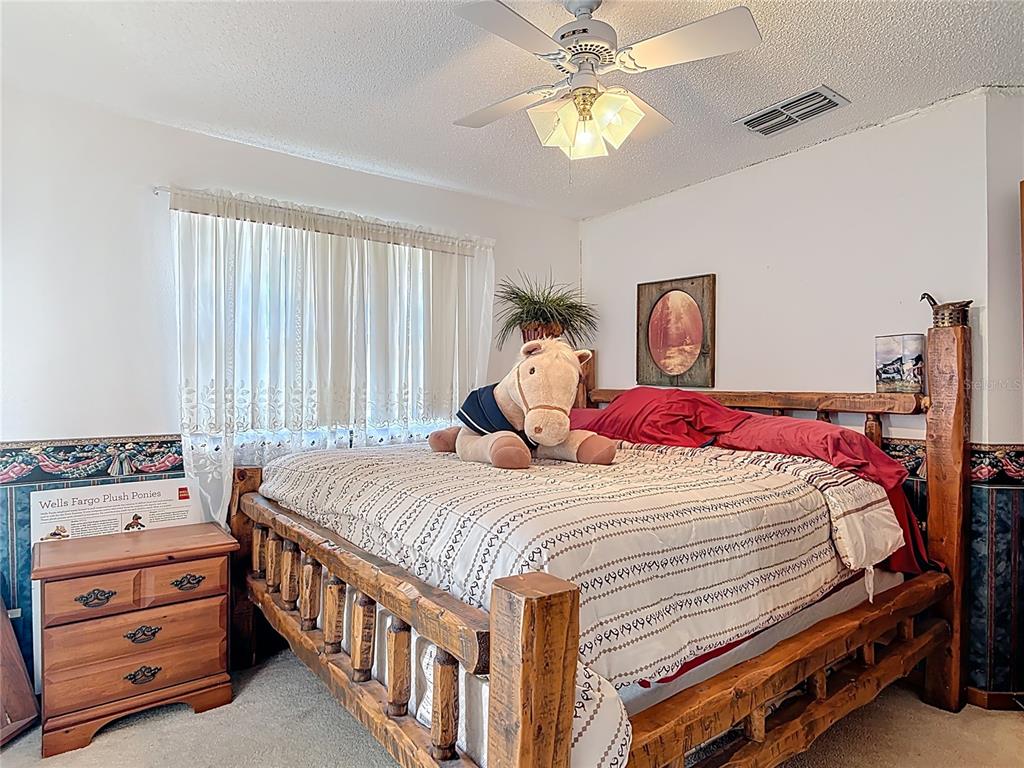 24545 Snail Road Astor, FL 32102 - Photo 15 of 61 a bedroom with a bed and a chandelier
