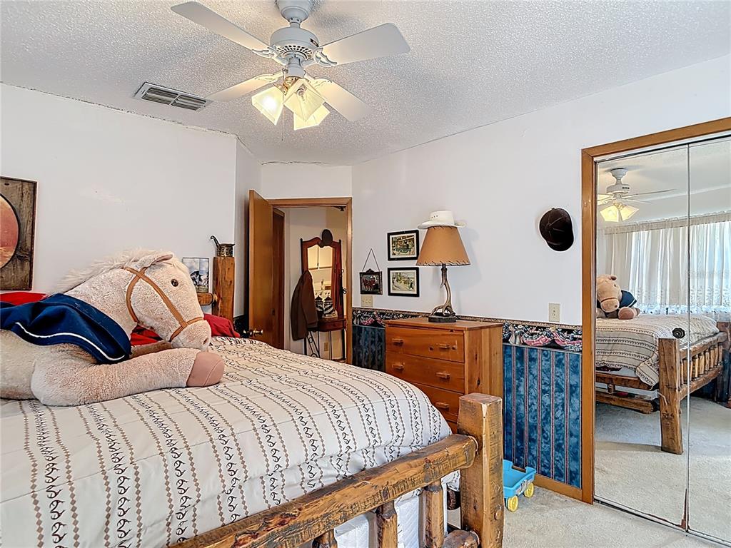 24545 Snail Road Astor, FL 32102 - Photo 16 of 61 a bedroom with a bed and a chandelier