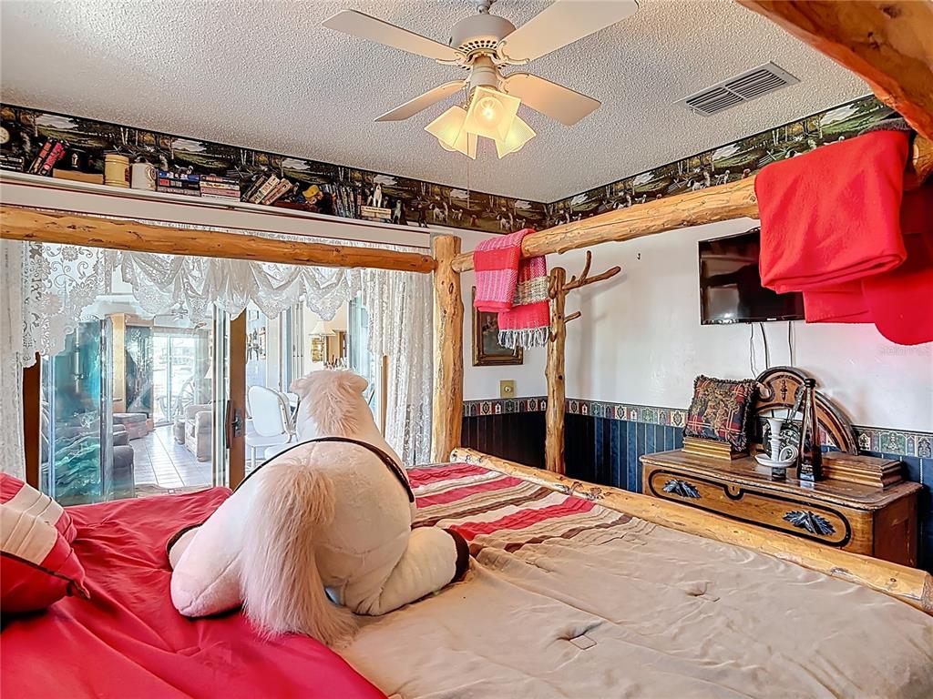 24545 Snail Road Astor, FL 32102 - Photo 17 of 61 a bedroom with a bed and lamp with the floor