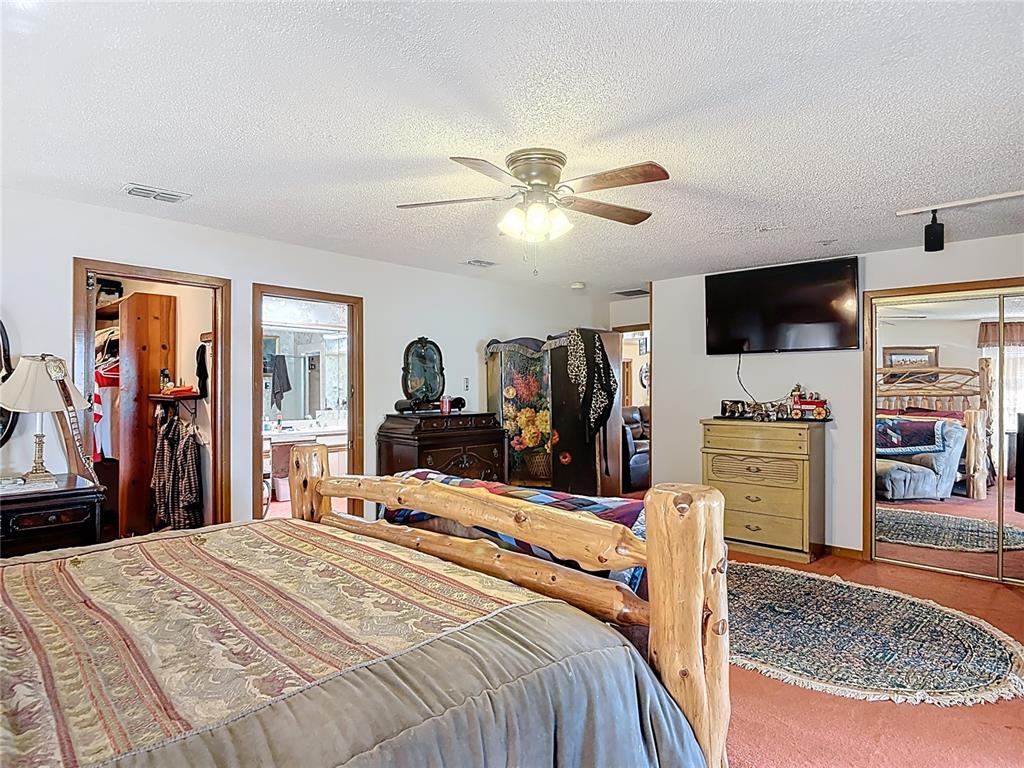 24545 Snail Road Astor, FL 32102 - Photo 21 of 61 a bedroom with a bed and a flat tv screen on dresser