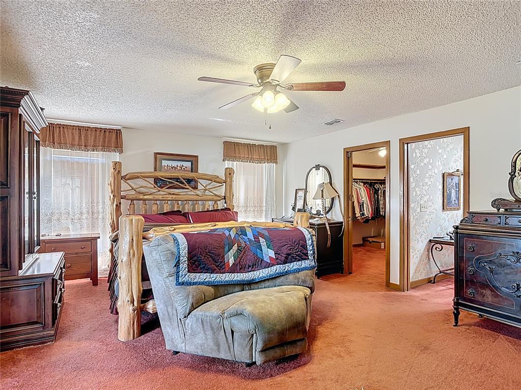 24545 Snail Road Astor, FL 32102 - Photo 22 of 61 a bedroom with a bed and a chandelier