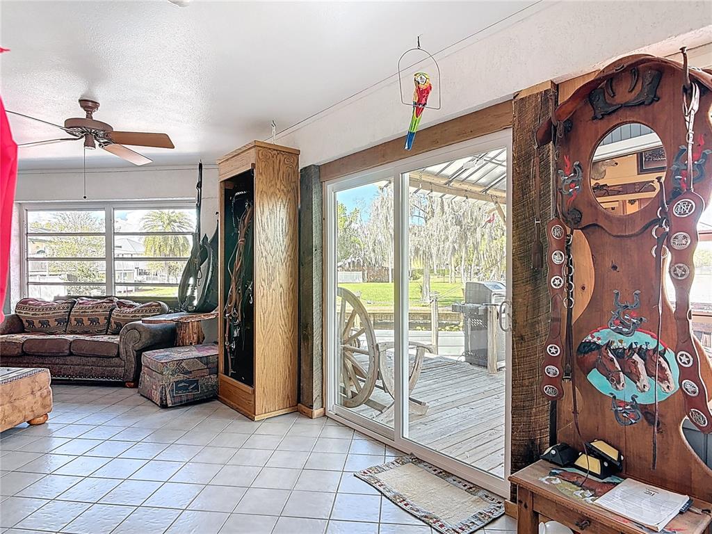 24545 Snail Road Astor, FL 32102 - Photo 31 of 61 a living room with furniture a floor to ceiling window and flat screen tv