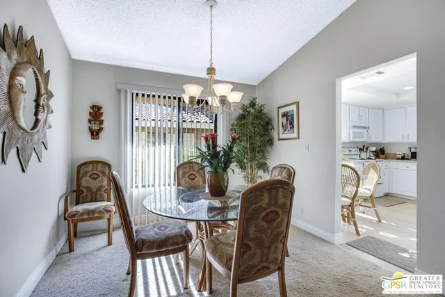 a dining room with furniture a chandelier and window