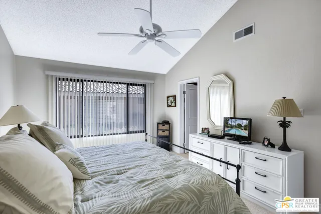 a bedroom with a large bed and a chandelier
