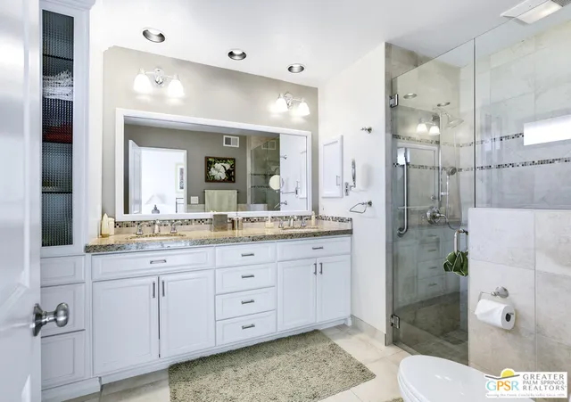 a bathroom with a granite countertop sink mirror and toilet