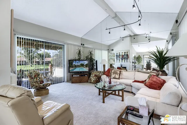a living room with furniture and a floor to ceiling window