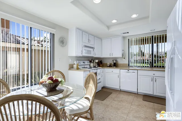 a kitchen that has a lot of cabinets a sink and appliances in it