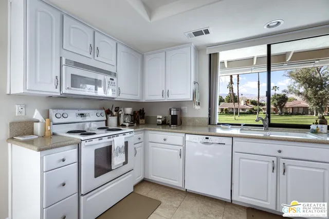 a kitchen with cabinets appliances and a window