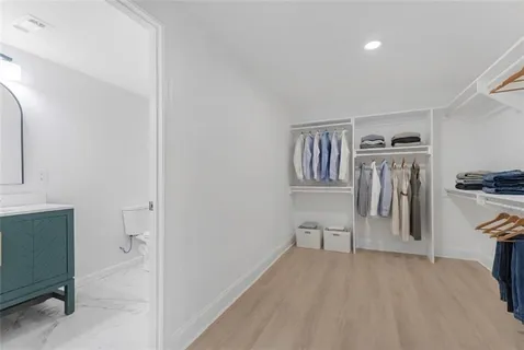 a view of a livingroom with wooden floor and a kitchen space