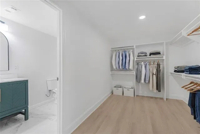 a view of a livingroom with wooden floor and a kitchen space