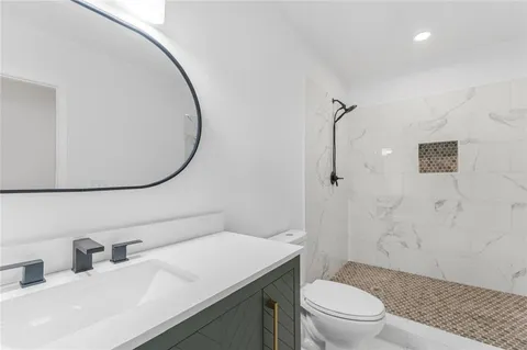 a bathroom with a sink a toilet and shower