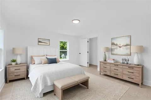 a bedroom with a bed and a lamp on dresser