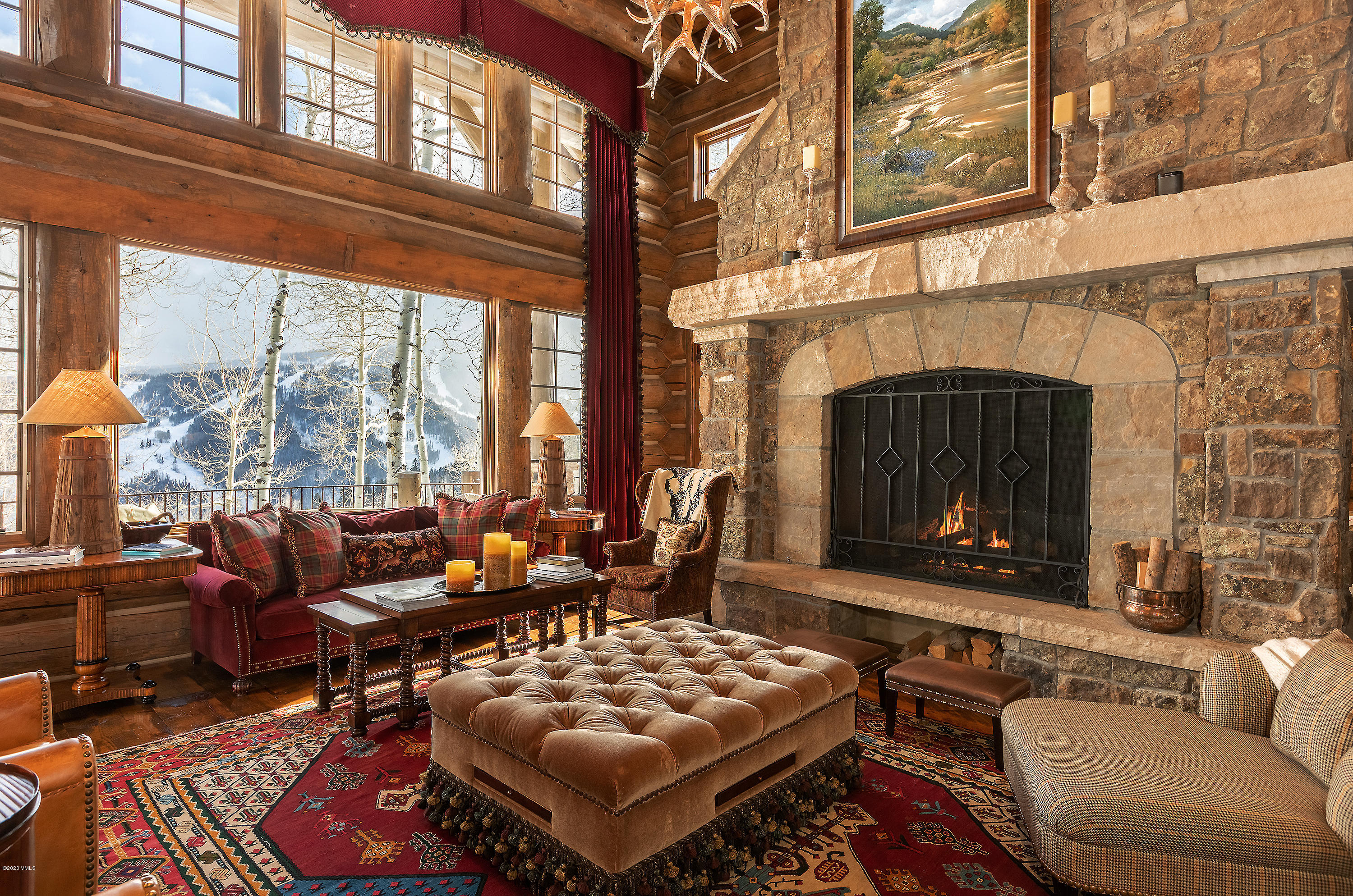 3389 Daybreak Ridge Road Avon, CO 81620 - Photo 3 of 24 a living room with furniture a fireplace and a floor to ceiling window