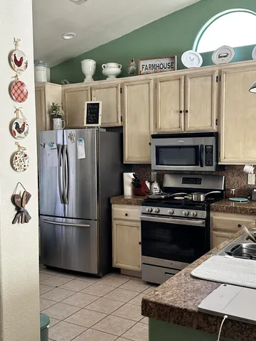 a kitchen with stainless steel appliances granite countertop a refrigerator and a stove top oven