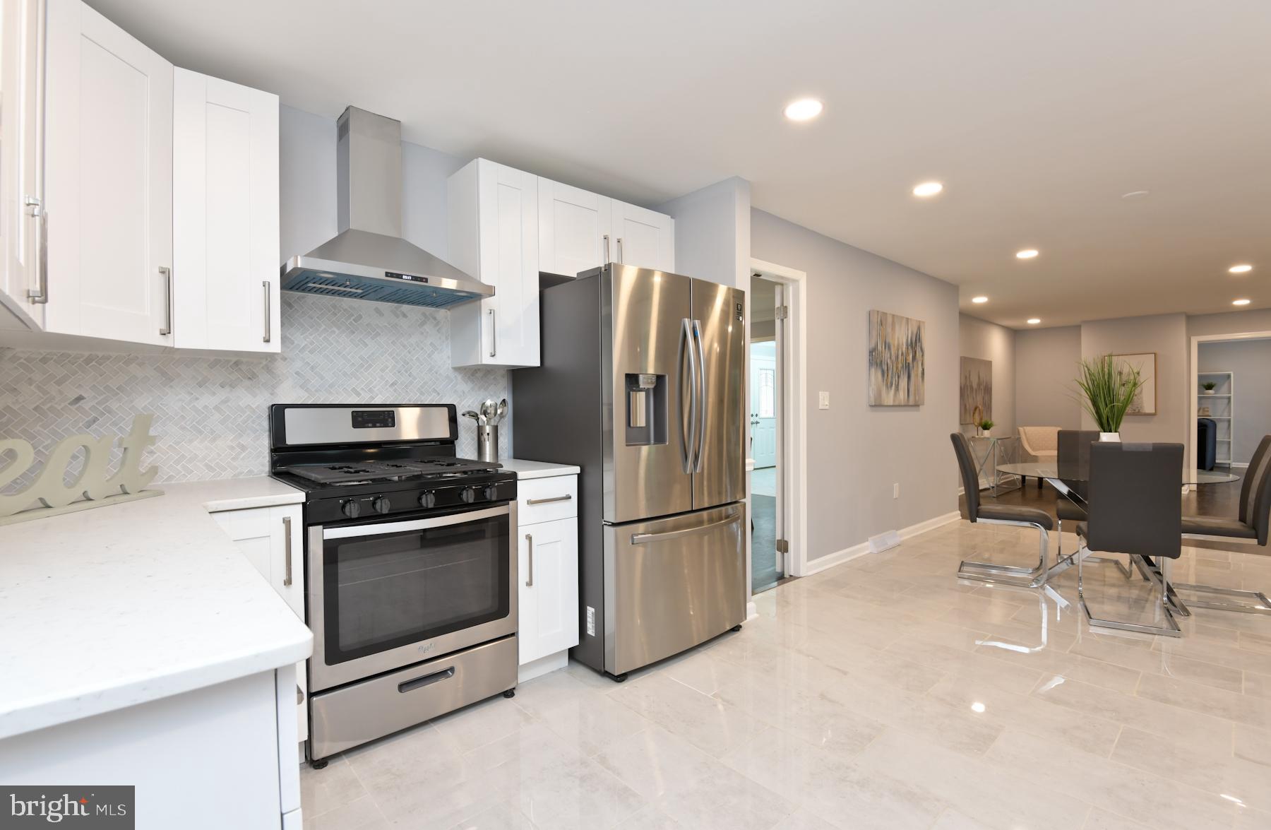 71 Carter Road Lawrence Township, NJ 08648 - Photo 13 of 33 a kitchen with stainless steel appliances granite countertop a stove a refrigerator a sink a dining table and chairs