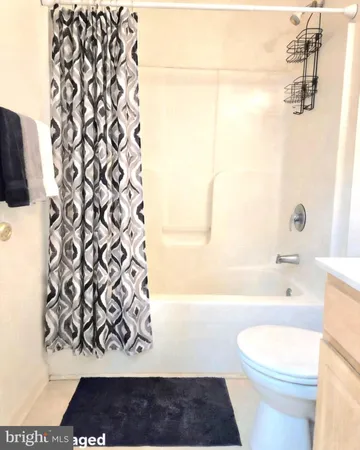 a bathroom with a toilet and a shower curtain