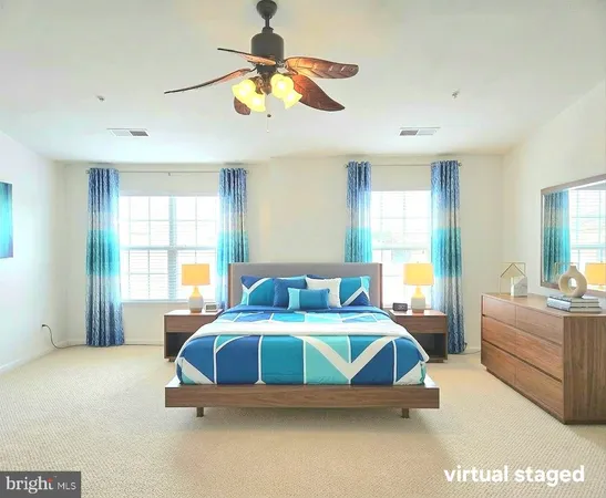 a bedroom with a bed a ceiling fan and a large window