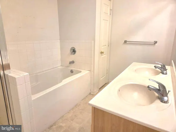 a bathroom with a tub sink and vanity