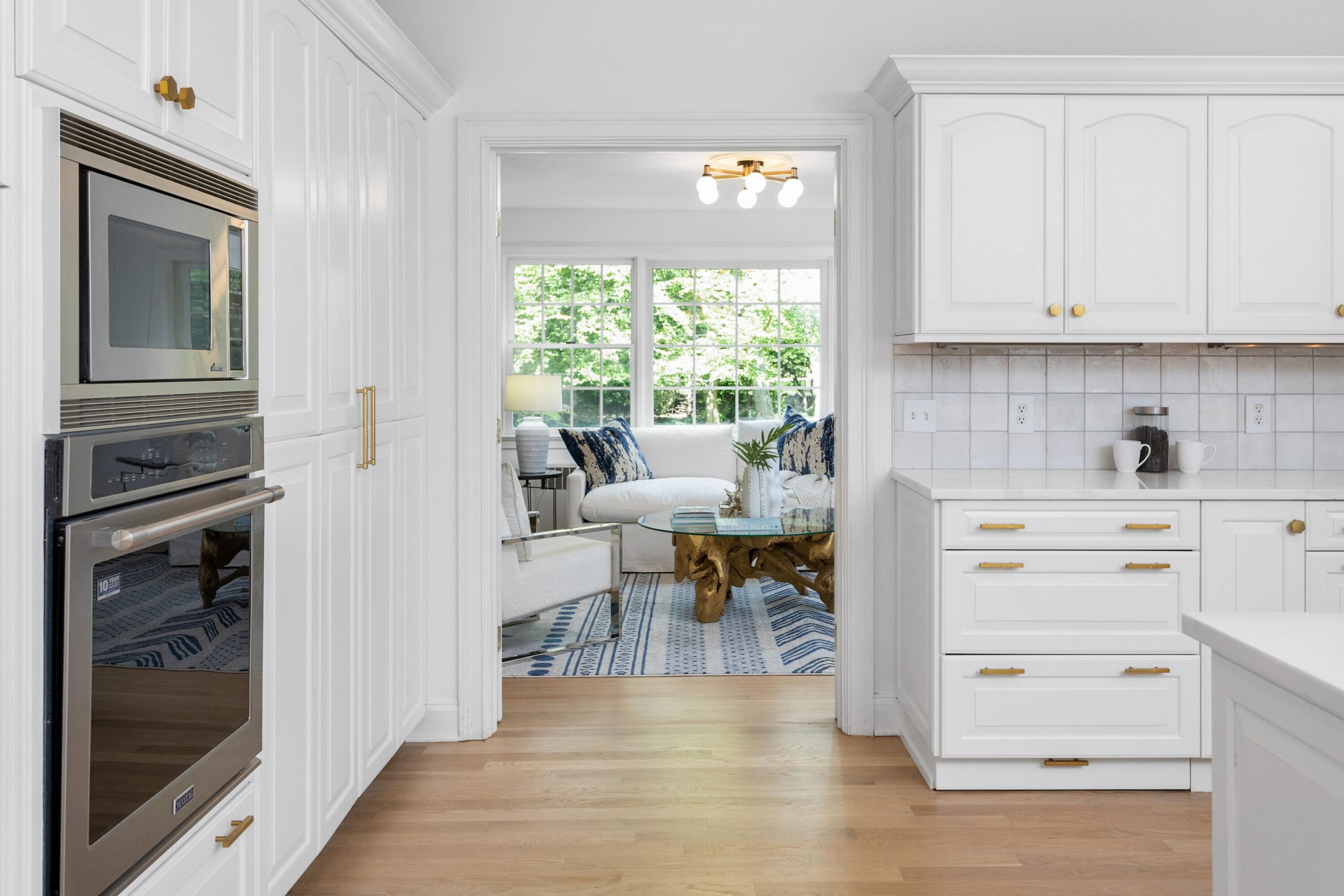 215 Leroy Avenue Darien, CT 06820 - Photo 11 of 34 a kitchen with white cabinets and a wooden floor