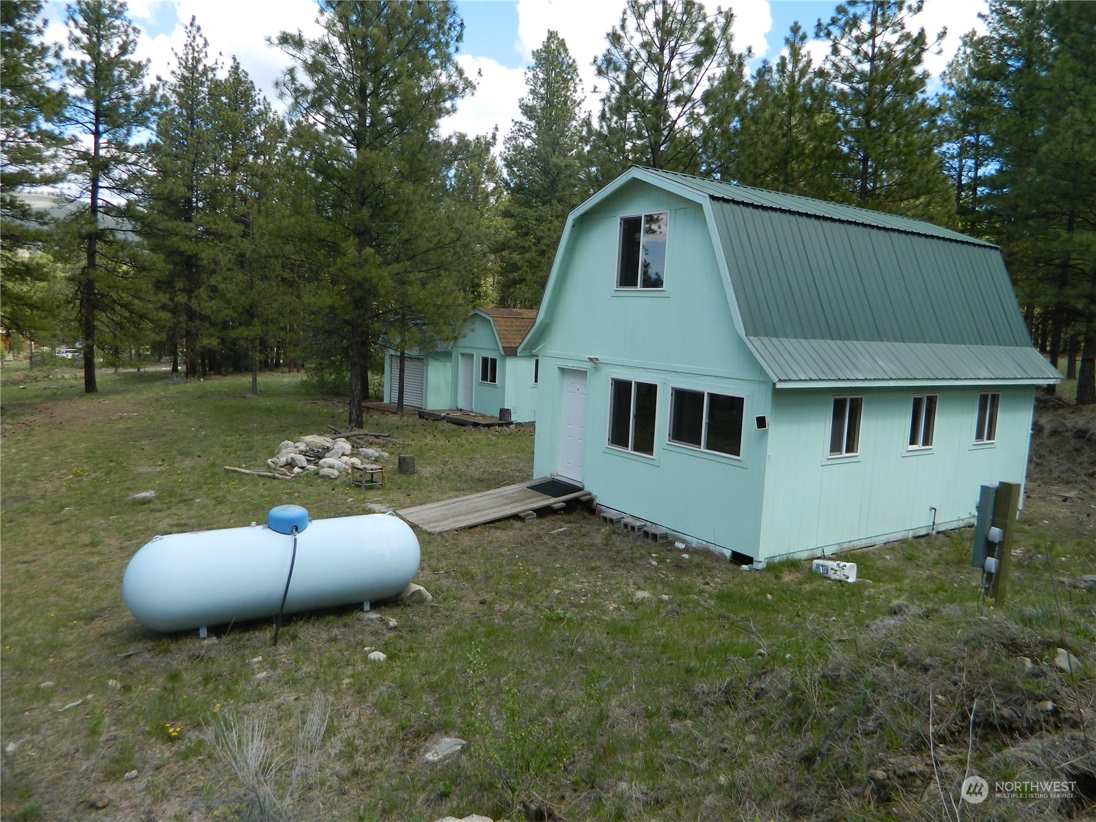 210 Main Road Tonasket, WA 98855 - Photo 1 of 39 a house with trees in the background