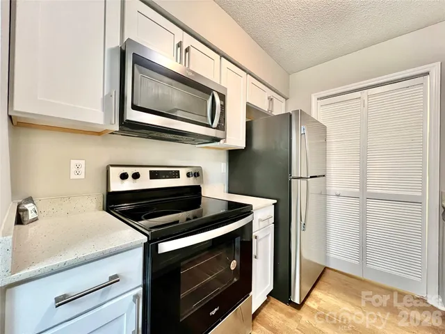 a kitchen with stainless steel appliances a refrigerator stove and microwave