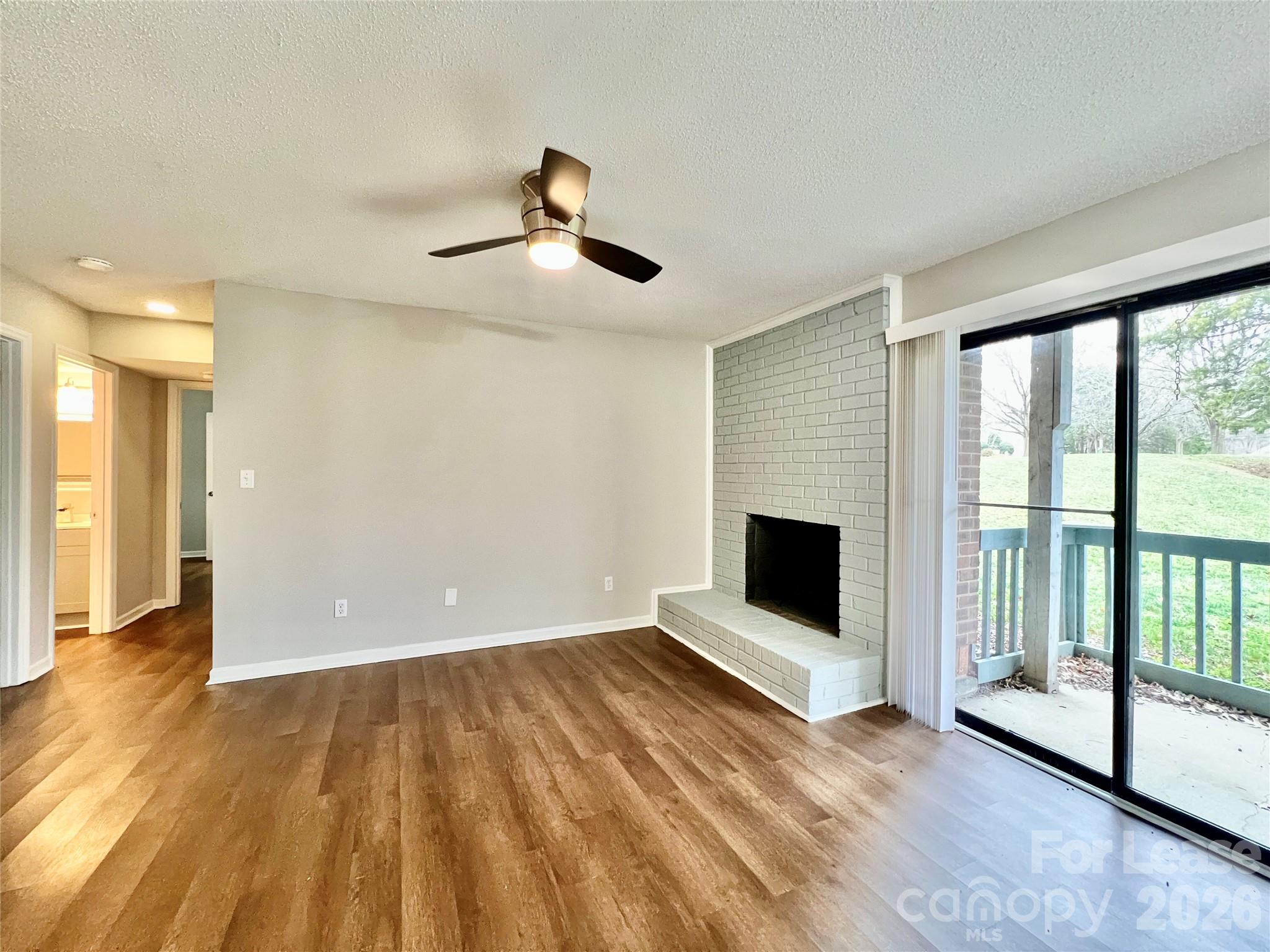 11084 Harrowfield Road Charlotte, NC 28226 - Photo 15 of 31 a view of a livingroom with wooden floor and a fireplace