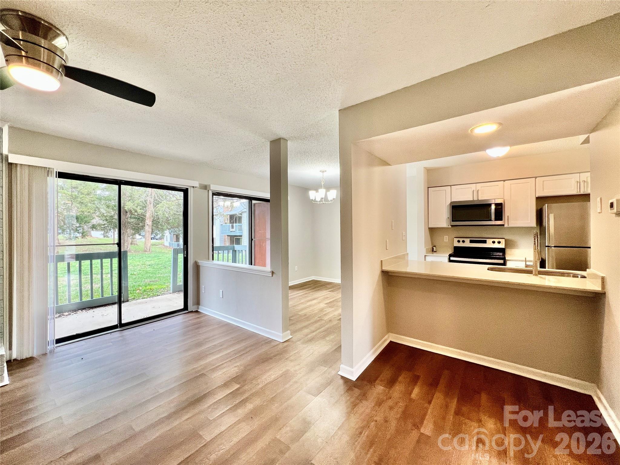 11084 Harrowfield Road Charlotte, NC 28226 - Photo 7 of 31 a view of a kitchen with wooden floor and outdoor space