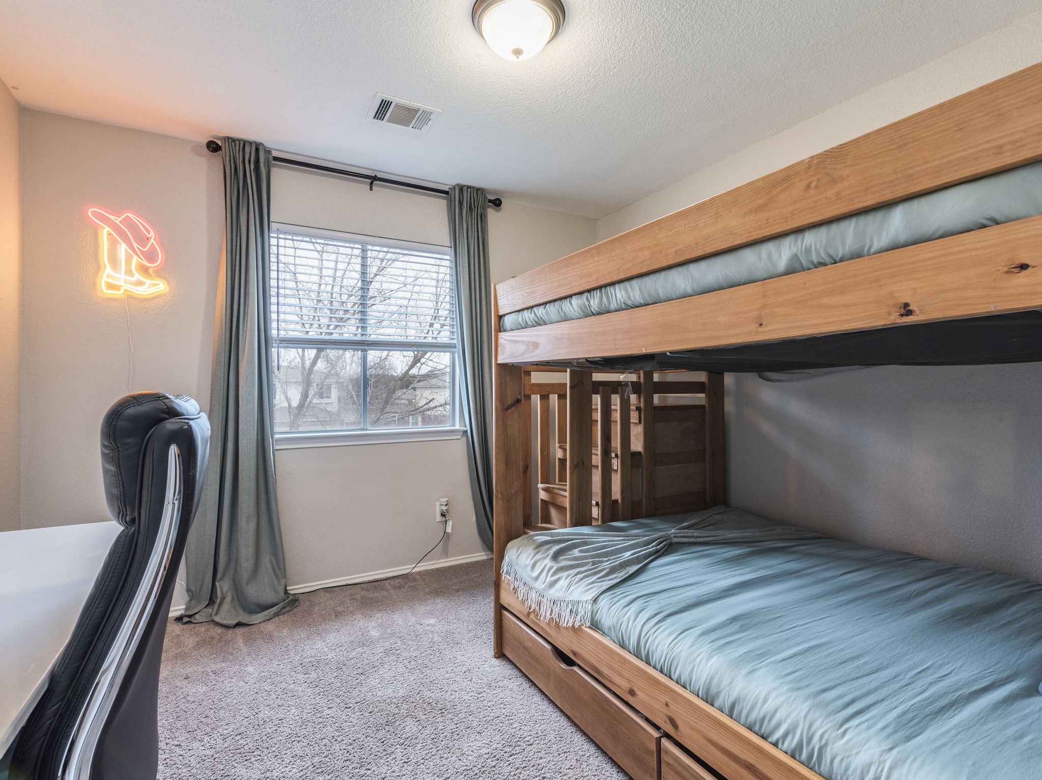 1415 Roxanne's Run Pflugerville, TX 78660 - Photo 20 of 30 A well-lit bedroom featuring durable carpeted flooring and a sturdy bunk bed with integrated storage.