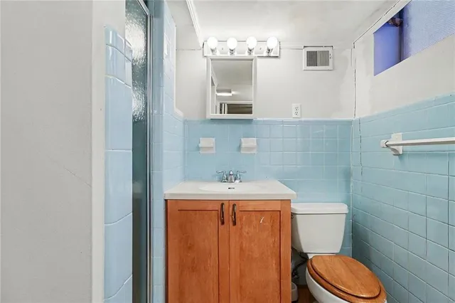 a bathroom with a granite countertop toilet sink and mirror