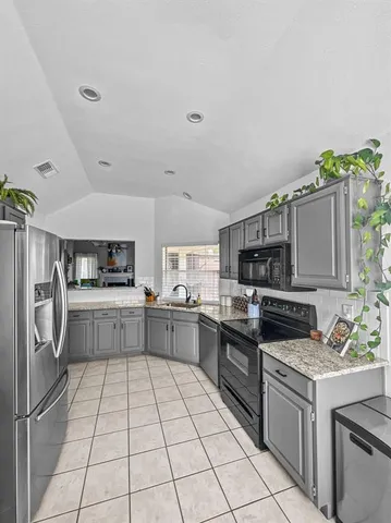 a kitchen with stainless steel appliances granite countertop a refrigerator and a stove top oven