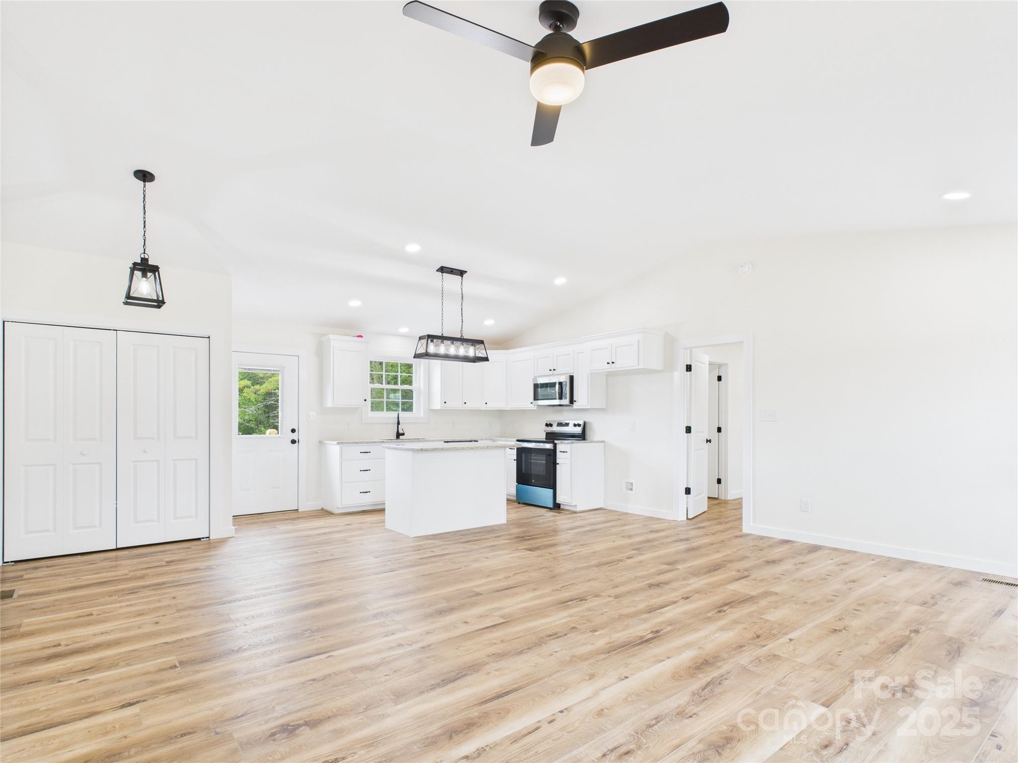 3016 Icard Rhodhiss Road Connelly Springs, NC 28612 - Photo 3 of 20 a large room with kitchen island white cabinets and wooden floor