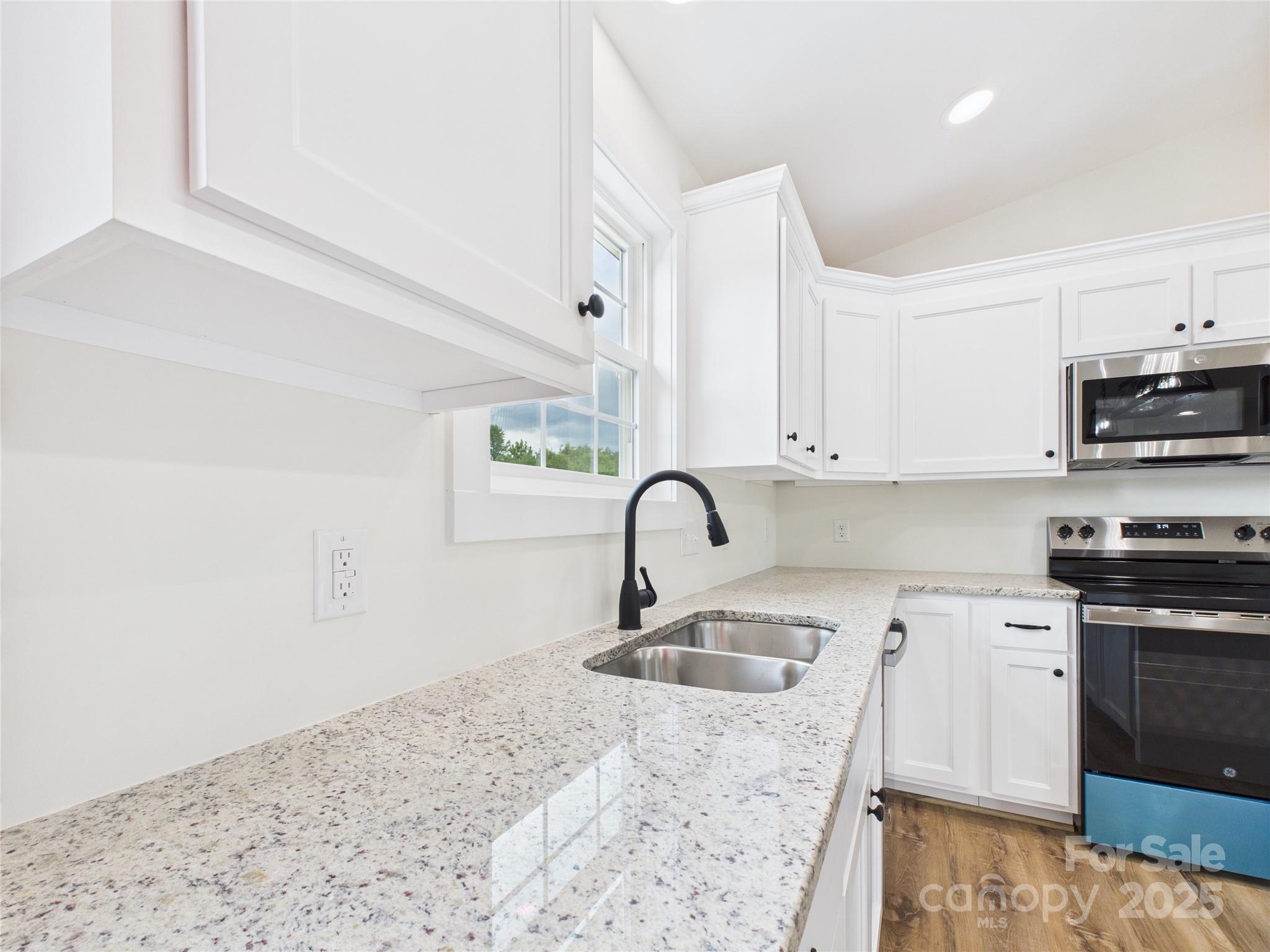 3016 Icard Rhodhiss Road Connelly Springs, NC 28612 - Photo 5 of 20 a kitchen with stainless steel appliances granite countertop a sink a stove top oven a counter space and cabinets
