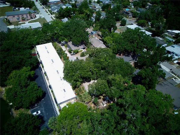 an aerial view of residential house with outdoor space and trees all around