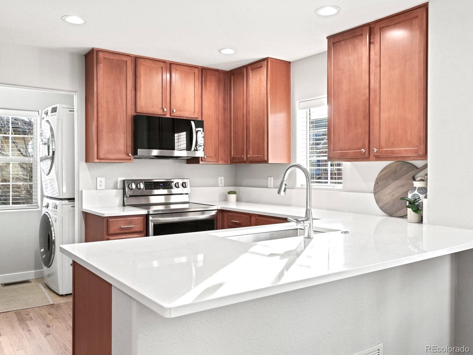 2230 Valentia Street Denver, CO 80238 - Photo 3 of 18 a kitchen with stainless steel appliances a stove a sink a microwave and cabinets