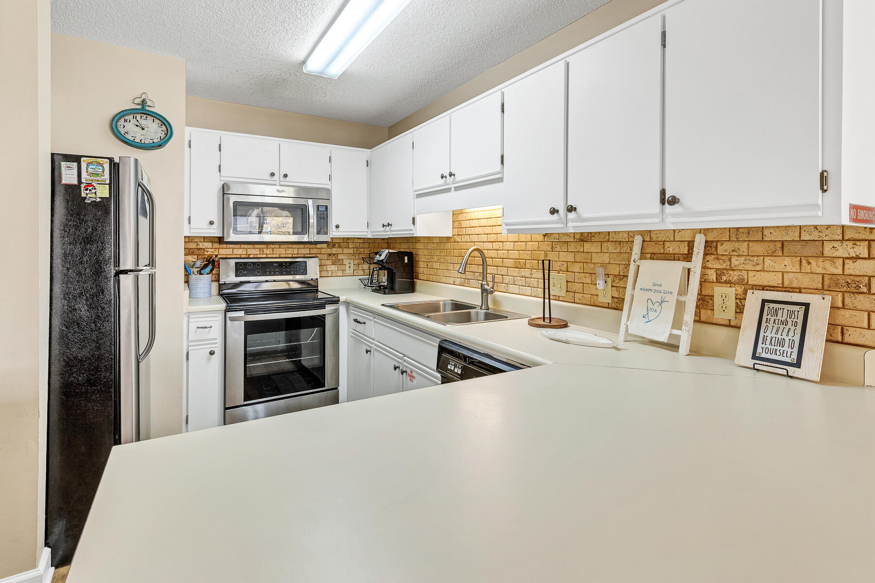 3799 East County Highway 30A, Unit D10 Santa Rosa Beach, FL 32459 - Photo 25 of 42 a kitchen with stainless steel appliances a refrigerator sink and cabinets