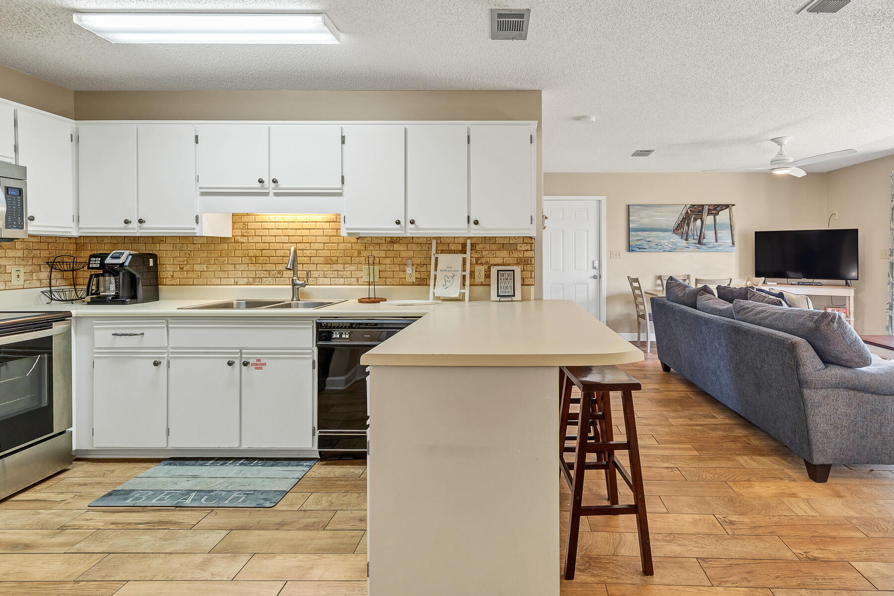 3799 East County Highway 30A, Unit D10 Santa Rosa Beach, FL 32459 - Photo 26 of 42 a kitchen with stainless steel appliances granite countertop a stove a sink dishwasher and a refrigerator with white cabinets