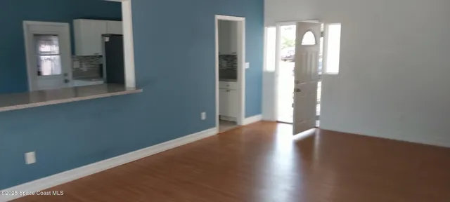 an empty room with wooden floor and a mirror