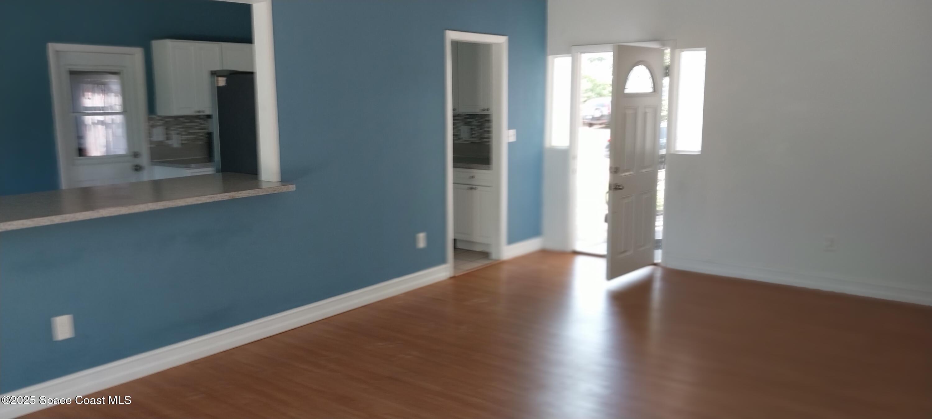 an empty room with wooden floor and a mirror